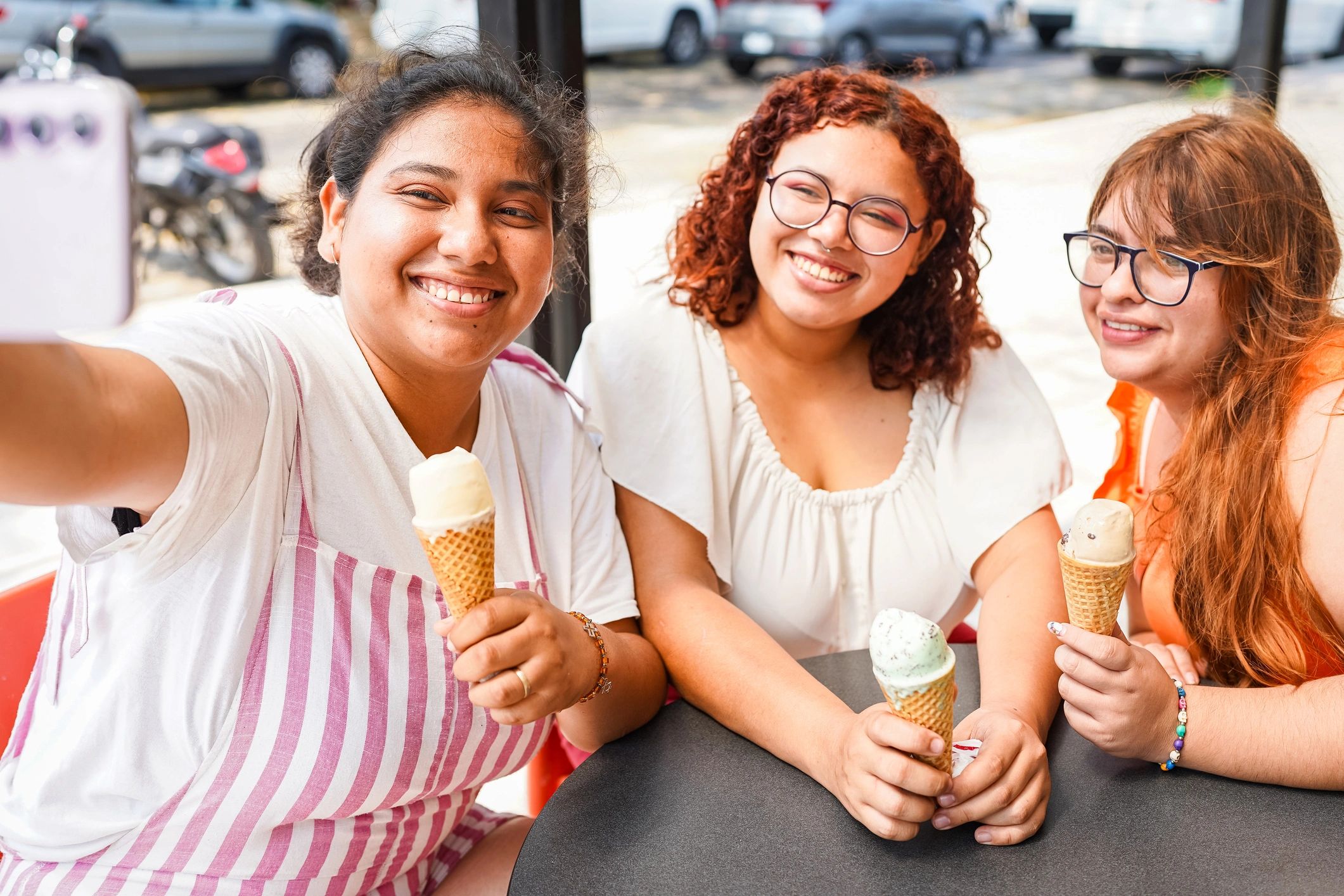 Friends taking a selfie while eating ice cream outdoors
