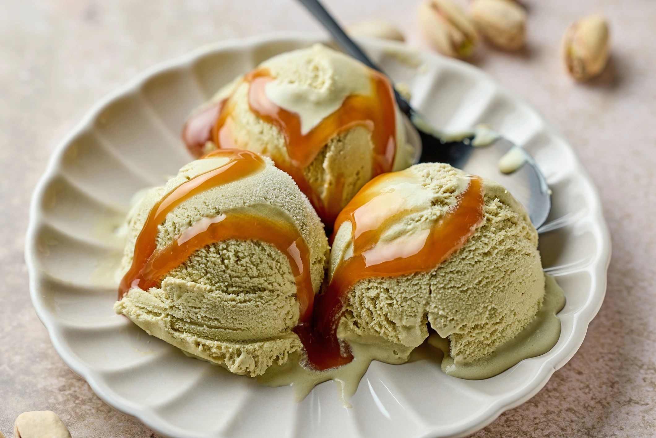 Pistachio ice cream scoops with caramel drizzle