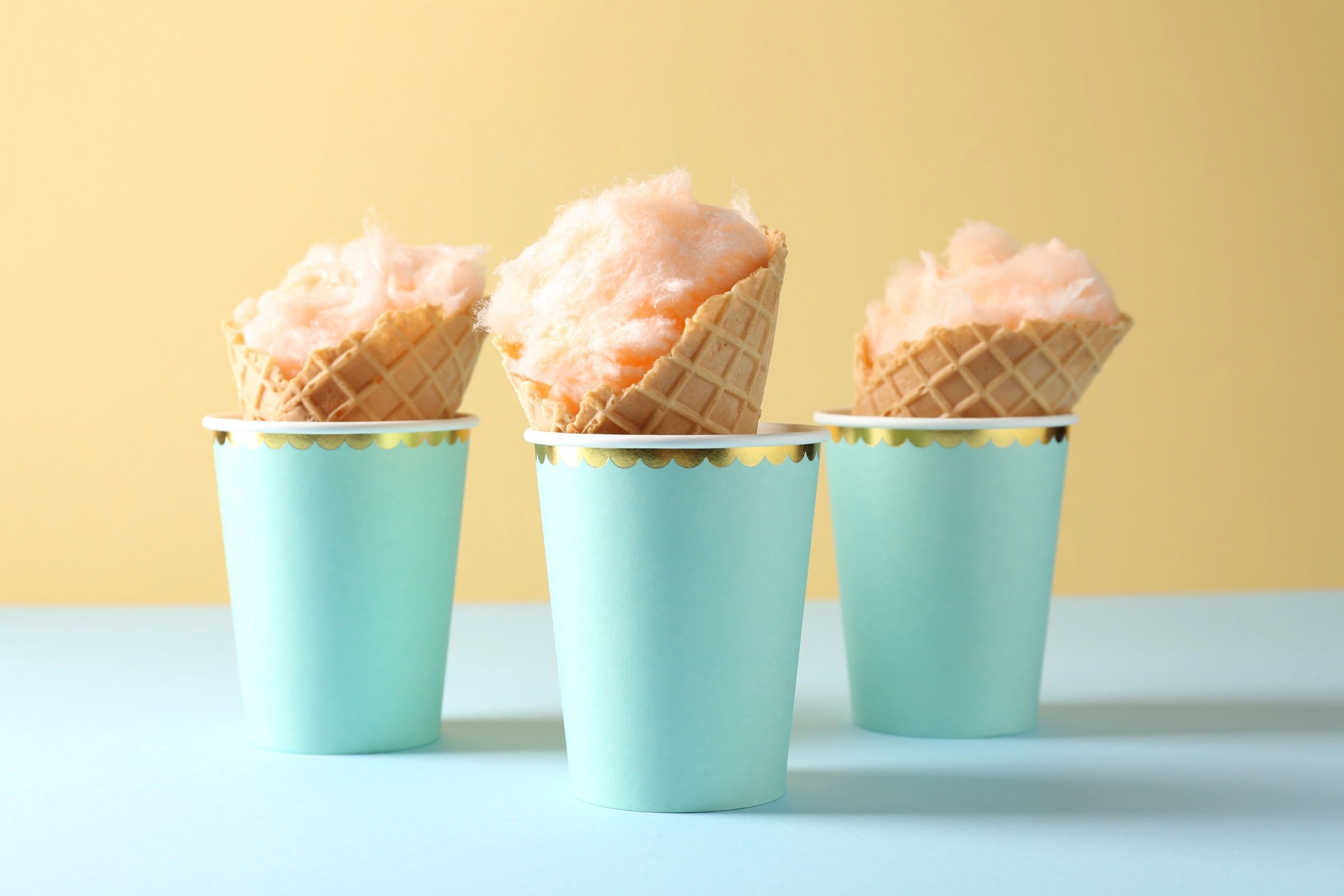 Pastel treats in waffle cones on a colorful background